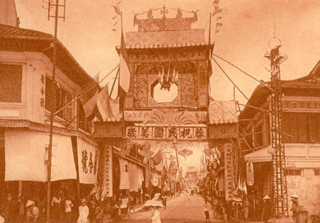 Fig. 32. Fernand Nadal, from Album Nadal, 1926: Canton Street (now Triệu Quang Phục). This image also appeared as a postcard. Probably it is the national holiday commemorating the establishment of the Republic of China on October 10, 1911. At the head and end of the street are congratulatory gates with the Chinese inscription, “Ten thousand years to the Republic.”  On the left side of the gate hang the tricolor flags of France. 