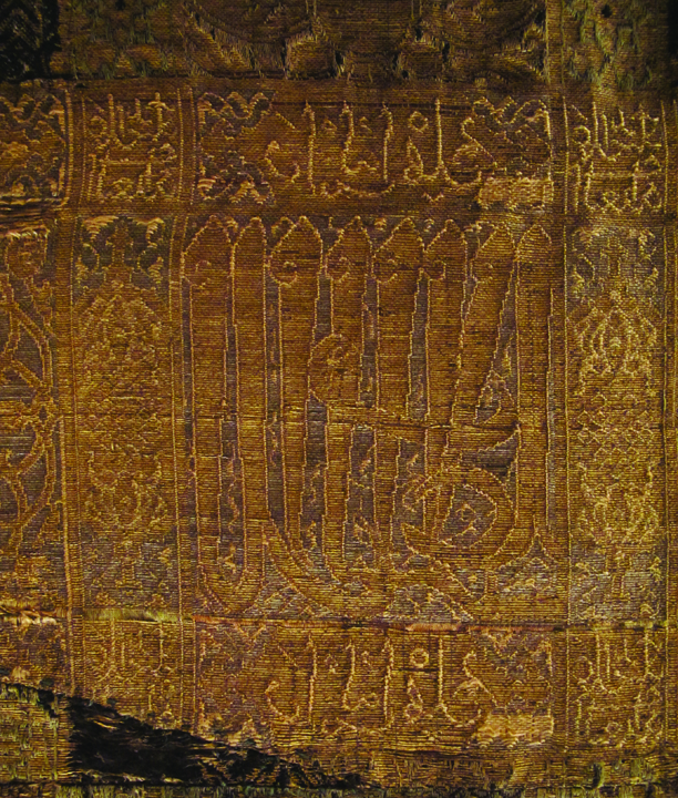 Figure 12. Detail of the Arabic inscriptions on the horizontal band from silk Ia within the dalmatic. Photograph by Corinne Mühlemann Figure 12. Detail of the Arabic inscriptions on the horizontal band from silk Ia within the dalmatic. Photograph by Corinne Mühlemann