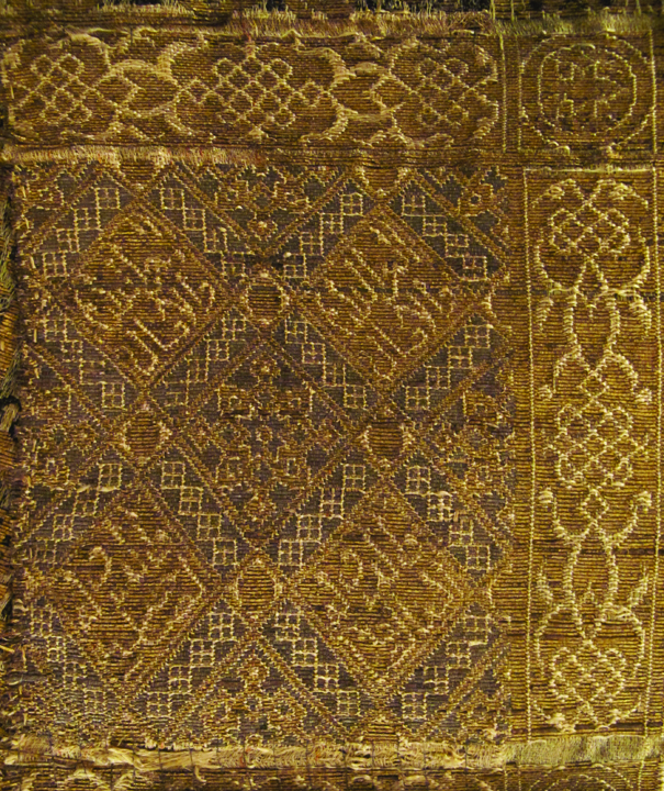 Figure 13. Detail of the Arabic inscriptions on the horizontal band from silk Ib within the dalmatic. Photograph by Corinne Mühlemann Figure 13. Detail of the Arabic inscriptions on the horizontal band from silk Ib within the dalmatic. Photograph by Corinne Mühlemann