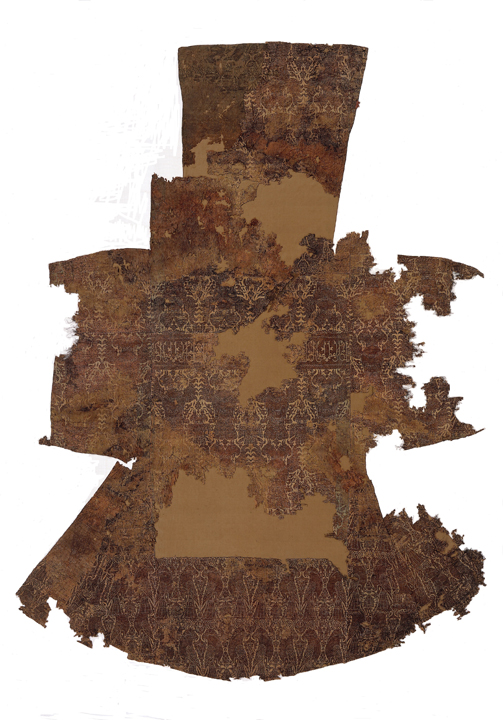 Figure 15. Reconstructed garment made of two different silks with a horizontal band in the area of the shoulders, Afghanistan or Eastern Iran, first half of the 13th century. Lampas with a gold thread (gilded leather strips wound around a linen core) as pattern weft (lancé). Abegg-Stiftung, Riggisberg, inv. nos. 5176, 5285, 5423. ©Abegg-Stiftung, CH-3132 Riggisberg, 2011. Photo by Christoph von Viràg Figure 15. Reconstructed garment made of two different silks with a horizontal band in the area of the shoulders, Afghanistan or Eastern Iran, first half of the 13th century. Lampas with a gold thread (gilded leather strips wound around a linen core) as pattern weft (lancé). Abegg-Stiftung, Riggisberg, inv. nos. 5176, 5285, 5423. ©Abegg-Stiftung, CH-3132 Riggisberg, 2011. Photo by Christoph von Viràg