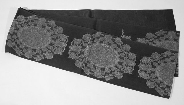 Obi.
Black gauze fukuro obi with large hôsôge floral medallions, 1960-1980s.
Black leno weave (gauze) silk with floral patterns woven in red-lacquered paper, gold-coated paper, and a turquoise metal-coated paper, 426 x 31 cm.
Gift of Howard and Patricia Yamaguchi, 2005/1.334 Obi.
Black gauze fukuro obi with large hôsôge floral medallions, 1960-1980s.
Black leno weave (gauze) silk with floral patterns woven in red-lacquered paper, gold-coated paper, and a turquoise metal-coated paper, 426 x 31 cm.
Gift of Howard and Patricia Yamaguchi, 2005/1.334