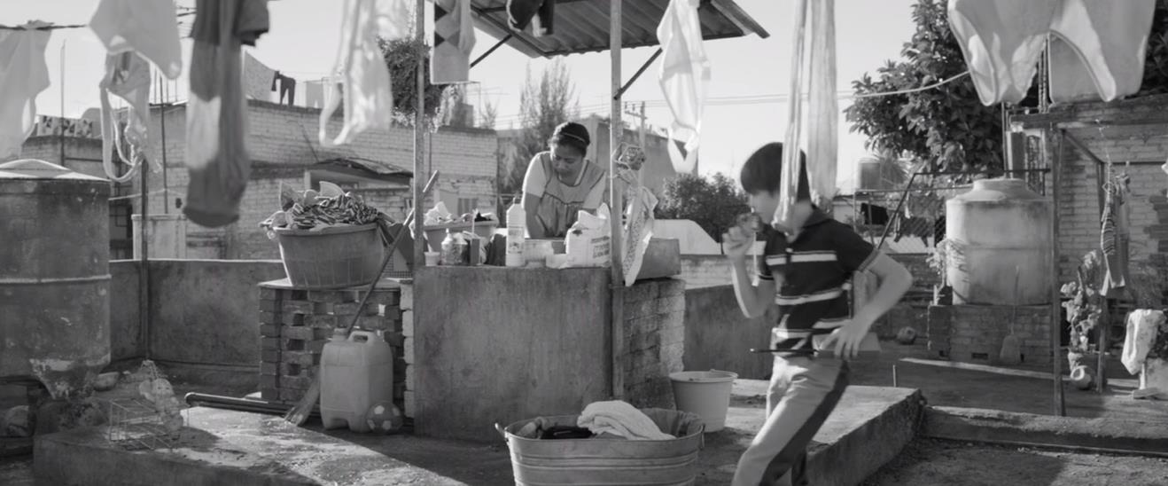 Figure 1: On her employer’s rooftop, Cleo (Yalitza Aparicio) washes clothing by hand as Paco (Carlos Peralta) plays hide-and-seek with his siblings. Figure 1: On her employer’s rooftop, Cleo (Yalitza Aparicio) washes clothing by hand as Paco (Carlos Peralta) plays hide-and-seek with his siblings.