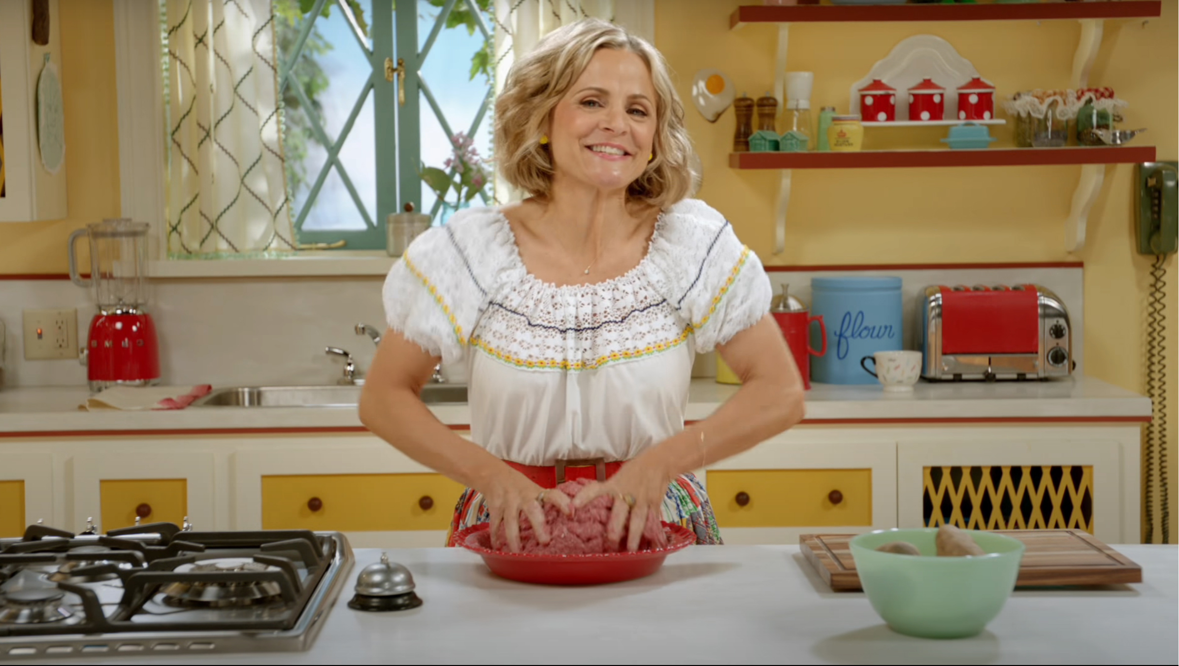 Figure 1. Amy Sedaris speaking to the audience from behind her kitchen counter in At Home with Amy Sedaris (season 1, episode 1, “Cooking for One,” aired October 24, 2017, on truTV). Figure 1. Amy Sedaris speaking to the audience from behind her kitchen counter in At Home with Amy Sedaris (season 1, episode 1, “Cooking for One,” aired October 24, 2017, on truTV).
