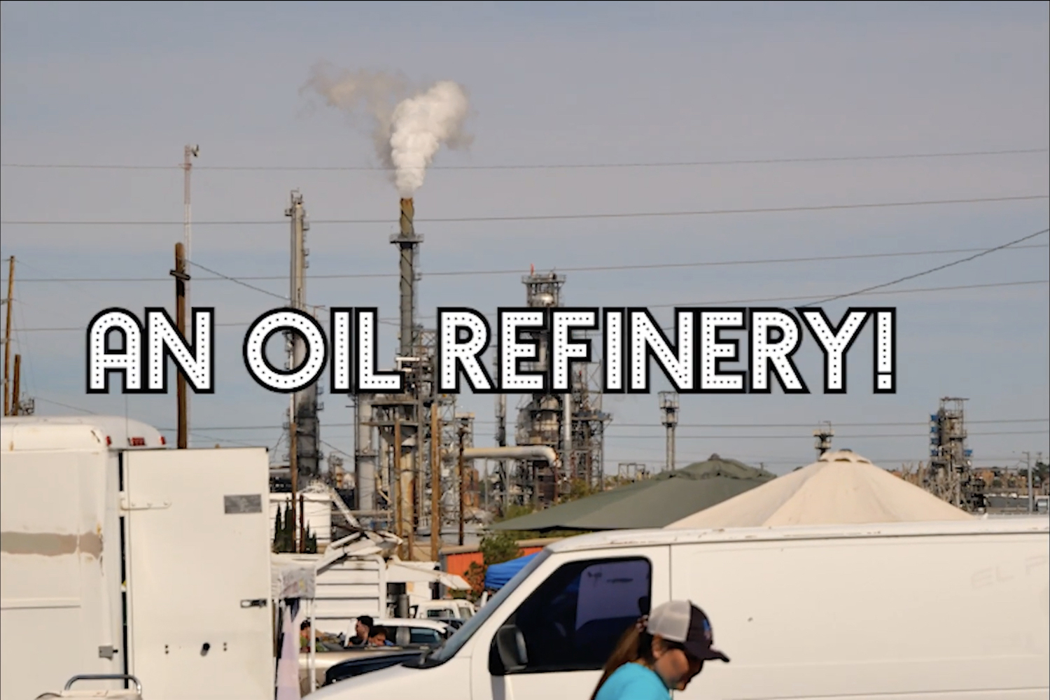 Figure 7. Screenshot of scene with on-screen text drawing attention to a the questionable presence of an oil refinery in the vicinity of the lively Ascarate Flea Market on the eastside of El Paso featured in “Ascarate Boogie” (Dir. Yudah Diaz, 2022). Figure 7. Screenshot of scene with on-screen text drawing attention to a the questionable presence of an oil refinery in the vicinity of the lively Ascarate Flea Market on the eastside of El Paso featured in “Ascarate Boogie” (Dir. Yudah Diaz, 2022).