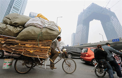 BEIJING, CHINA - A Chinese man rides a tricycle filled with goods near the ongoing construction of the China Central Television tower through the air pollution at the Central Business District in Beijing on April 8, 2008. TEH ENG KOON/AFP/Getty Images BEIJING, CHINA - A Chinese man rides a tricycle filled with goods near the ongoing construction of the China Central Television tower through the air pollution at the Central Business District in Beijing on April 8, 2008. TEH ENG KOON/AFP/Getty Images