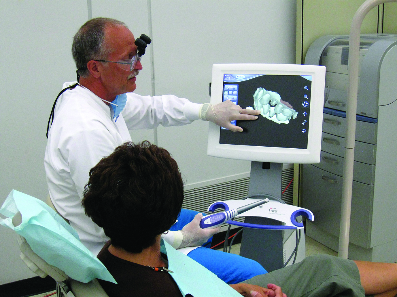 Dr. Dennis Fasbinder uses computer-aided design and computer-aided manufacturing (CAD/CAM) technology to describe treatment options to a patient. Dr. Dennis Fasbinder uses computer-aided design and computer-aided manufacturing (CAD/CAM) technology to describe treatment options to a patient.