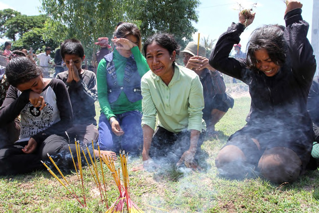 Sovan Philong, ‘Violent Scenes in a Rice Paddy 03’, 2009. Digital C-Print. A group of villagers cry and pray to the spirits of the land. One woman among them clutches pulled grass in her hands, filled with anger and grief. Courtesy the artist and Asia Motion. Sovan Philong, ‘Violent Scenes in a Rice Paddy 03’, 2009. Digital C-Print. A group of villagers cry and pray to the spirits of the land. One woman among them clutches pulled grass in her hands, filled with anger and grief. Courtesy the artist and Asia Motion.