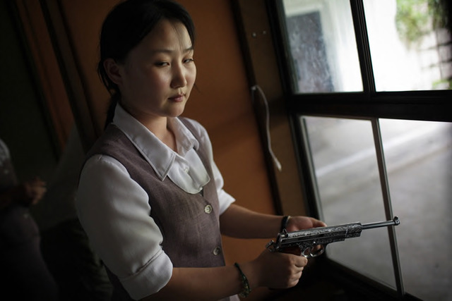 Fig. 3. Tomas van Houtryve, Korean woman loads a pistol for firing practice in Pyongyang, 2007. Archival pigment print, 16 x 24 in. Fig. 3. Tomas van Houtryve, Korean woman loads a pistol for firing practice in Pyongyang, 2007. Archival pigment print, 16 x 24 in.