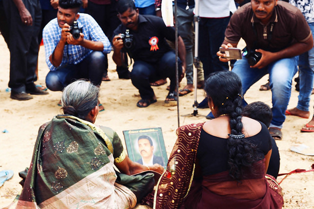 Fig. 4. A Tamil family mourns before a portrait at Mullivaikkal Remembrance Day that marks the end of the war, 2018. In the postwar, these humble everyday photographs, made for the most part by local photography studios during the course of the conflict, photographs spanning from NIC portraits to family snaps, feature in a vibrant political re-routing. The mobilisation of personal and official photographs within spaces of defiant commemoration where the state’s unease about Tamil nationalism endures, as well as spaces of protest have underscored the state’s prevarications on reconciliation and transitional justice. For the Sri Lankan Tamil community, photographs underpin their political claims bound to the inequities of citizenship where Sinhala Buddhist Nationalism has rapidly become the hegemonic basis for determining belonging as well as practicalities of citizenship. The use of these photographs has also itself become a genre for photo/journalists as they place such acts within a globalised aesthetic and lineage of resistance against state atrocities ranging from Argentina to Kashmir. Photograph by Vindhya Buthpitiya. Fig. 4. A Tamil family mourns before a portrait at Mullivaikkal Remembrance Day that marks the end of the war, 2018. In the postwar, these humble everyday photographs, made for the most part by local photography studios during the course of the conflict, photographs spanning from NIC portraits to family snaps, feature in a vibrant political re-routing. The mobilisation of personal and official photographs within spaces of defiant commemoration where the state’s unease about Tamil nationalism endures, as well as spaces of protest have underscored the state’s prevarications on reconciliation and transitional justice. For the Sri Lankan Tamil community, photographs underpin their political claims bound to the inequities of citizenship where Sinhala Buddhist Nationalism has rapidly become the hegemonic basis for determining belonging as well as practicalities of citizenship. The use of these photographs has also itself become a genre for photo/journalists as they place such acts within a globalised aesthetic and lineage of resistance against state atrocities ranging from Argentina to Kashmir. Photograph by Vindhya Buthpitiya.